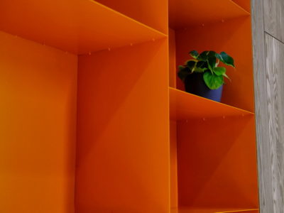 Яркий красивый оранжевый стеллаж для офиса встроенный в систему корпусной мебели