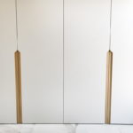 Шкаф в гардеробную с белыми фасадами и интегрированными ручками из шпона ясеня- Woodkivi